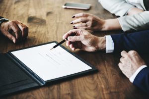 Three people looking at contract at table