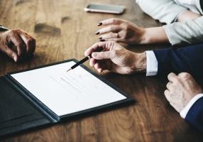 Three people looking at contract at table